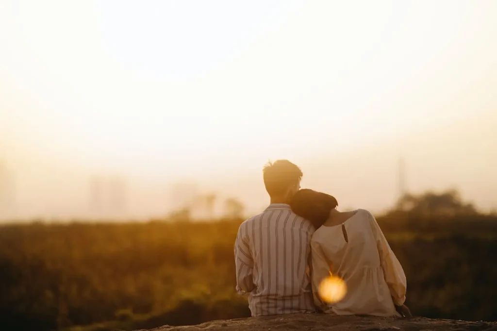 a man and woman sitting on a rock