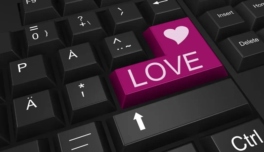 Close-up of black keyboard with pink ‘love’ button, symbolizing online conversations and romance