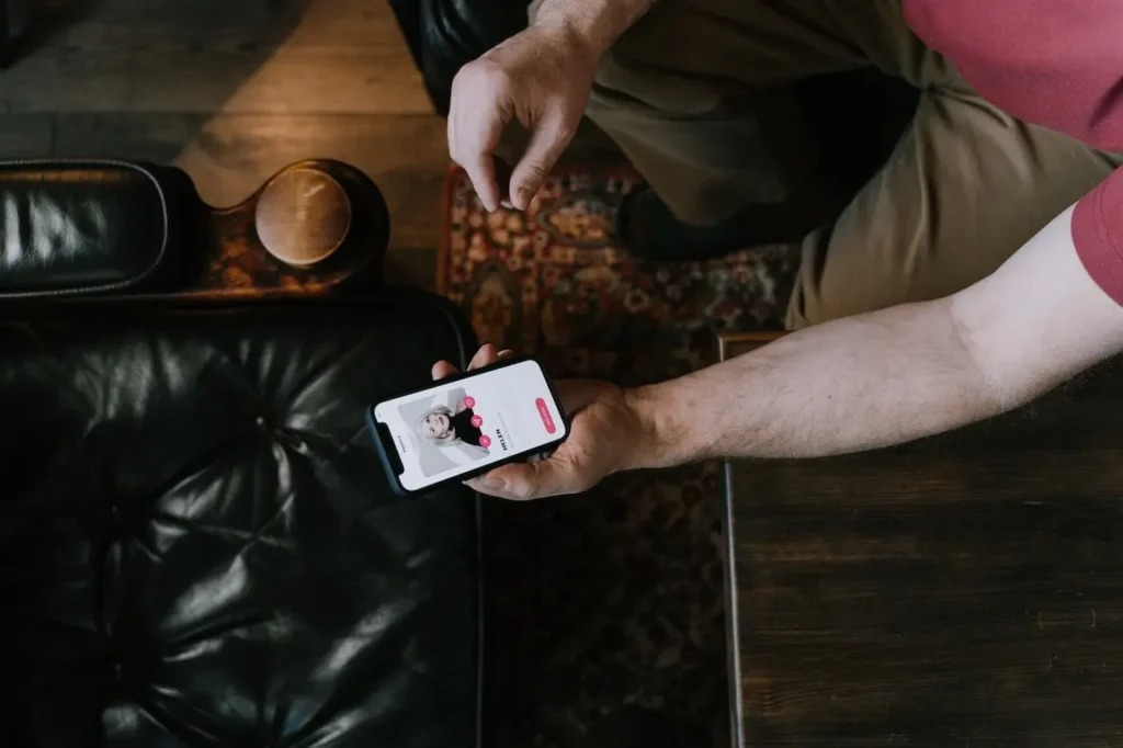Top view of a hand holding a phone with a dating app open, representing online dating dos and don’ts